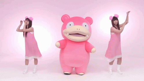 Two Women In Pink Dresses Are Dancing With A Pink Stuffed Animal In The Middle GIF