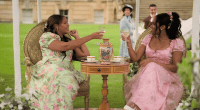 Two Women In Pink Dresses Drinking Wine GIF
