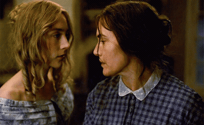 Two Women In Plaid Shirts Are Looking At Each Other GIF