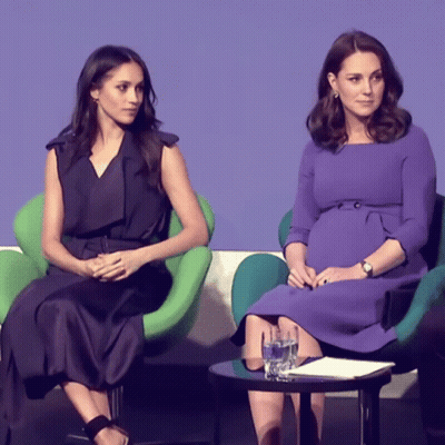 Two Women In Purple Dresses Sitting Together GIF