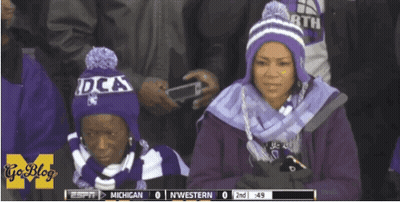 Two Women In Purple Hats Watching Michigan Vs Northwestern GIF