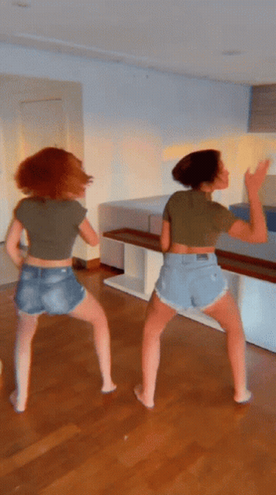 Two Women In Shorts And Crop Tops Dancing GIF