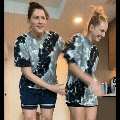 Two Women In Tie Dye Shirts Dancing GIF