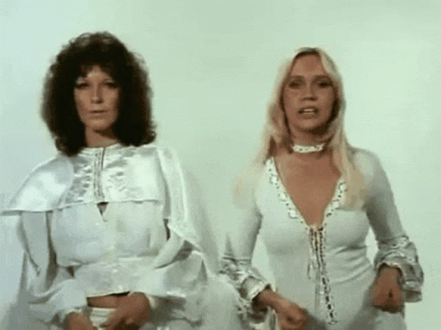 Two Women In White Dresses Are Standing Next To Each Other And Looking At The Camera . GIF