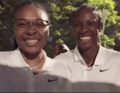 Two Women In White Nike Polo Shirts Smiling At Camera GIF