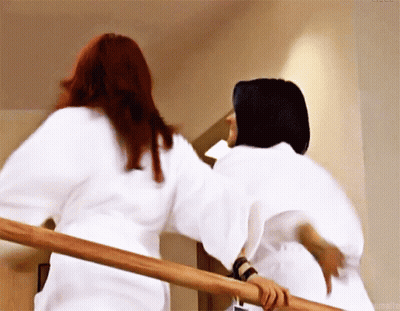 Two Women In White Robes Standing On Stairs GIF