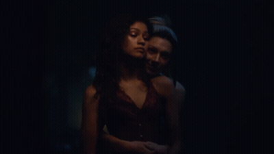 Two Women Kissing In Dark Room With Painting GIF