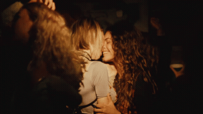 Two Women Kissing In Dark Room With Painting GIF