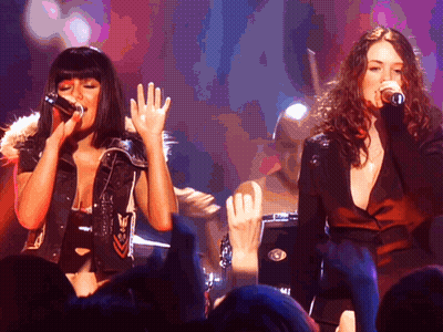 Two Women Kissing On Stage In Front Of NBC Sign GIF
