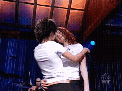 Two Women Kissing On Stage In Front Of NBC Sign GIF