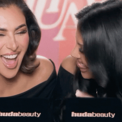 Two Women Laughing At Huda Beauty Sign GIF