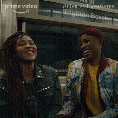 Two Women Laughing In Front Of Harlem Ever After Brighton Beach Sign GIF