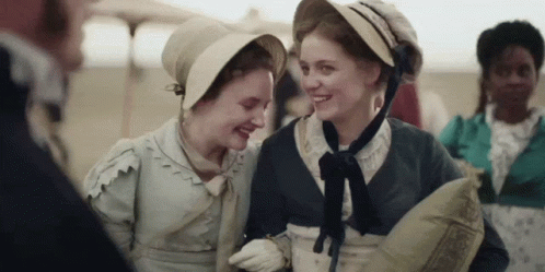 Two Women Laughing While Wearing Hats GIF