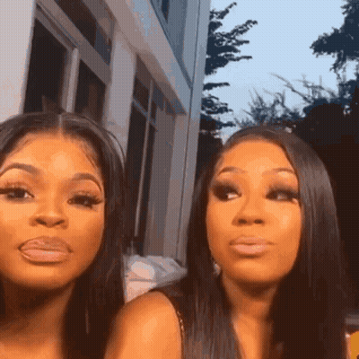 Two Women Looking At Camera In Front Of Building GIF