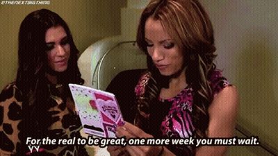 Two Women Looking At Card Saying For The Real To Be Great One More Week You Must Wait GIF