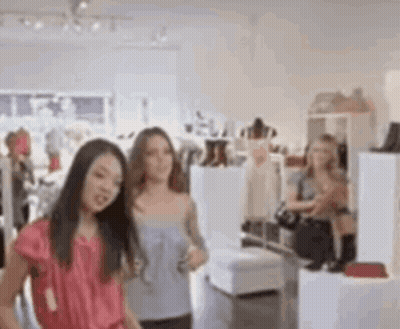 Two Women Looking At Clothes In Store GIF