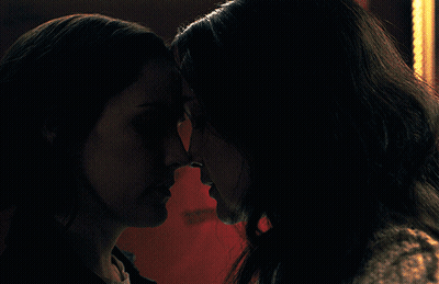 Two Women Looking At Each Other In Dark GIF