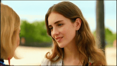 Two Women Looking At Each Other With Trees GIF