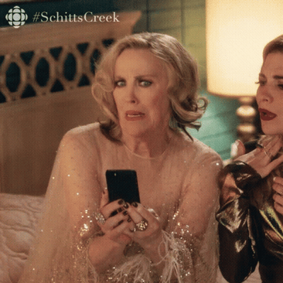 Two Women Looking At Phone With Schitts Creek Hashtag GIF