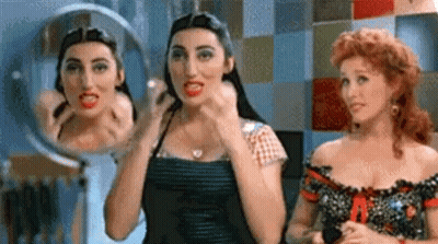 Two Women Looking At Themselves In Mirror GIF
