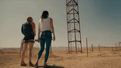 Two Women Looking At Tower In Field GIF