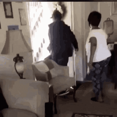 Two Women Looking Out Doorway In Living Room GIF