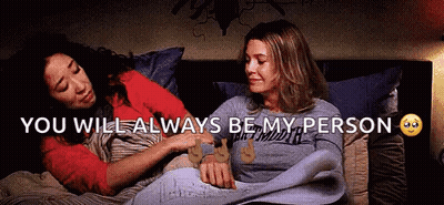 Two Women Lying In Bed Holding Hands GIF