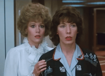 Two Women Next To Each Other One Wearing Jacket With Chinese Characters GIF