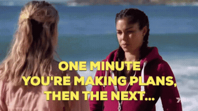 Two Women On Beach Saying One Minute You're Making Plans Then The Next GIF