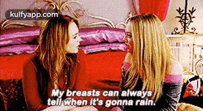 Two Women On Bed Talking Breasts GIF