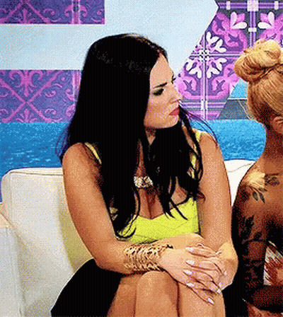 Two Women On Couch Legs Crossed One With Tattoo GIF