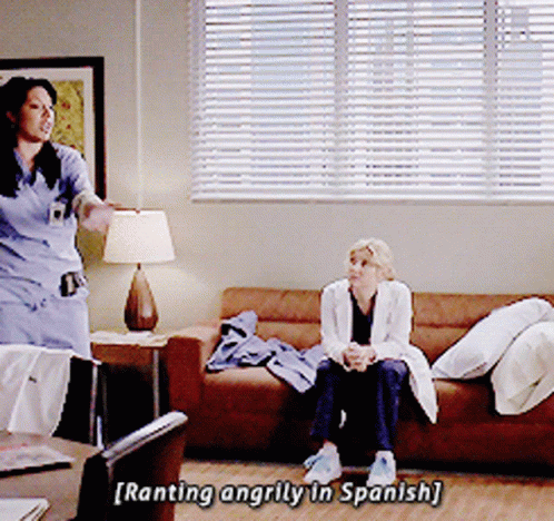 Two Women On Couch One Talking In Spanish GIF