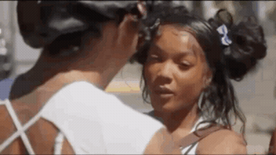 Two Women On Sidewalk Touching Face GIF