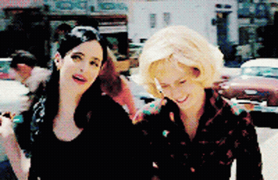 Two Women On Street, One Smoking GIF