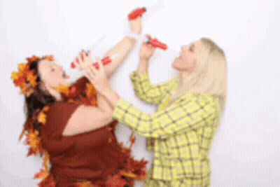 Two Women Playing With Hot Dogs And Leaves GIF