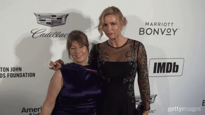 Two Women Pose On Red Carpet With Cadillac And Marriott Bonvoy Logo GIF