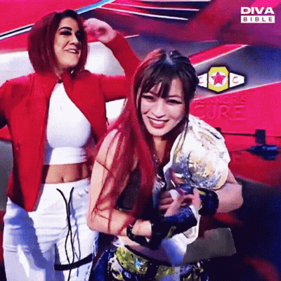 Two Women Posing in Front of Diva Bible Ad