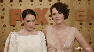Two Women Posing In Front Of Fox Logo GIF