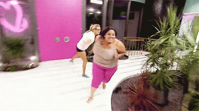 Two Women Running Past Pink Door Saying Q GIF