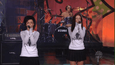 Two Women Singing In Front Of Tama Drum Set GIF