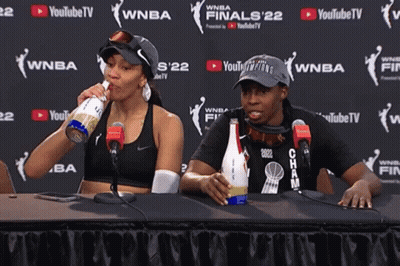 Two Women Sit At A Table In Front Of A Youtube Tv Sign GIF