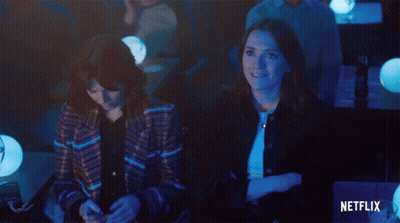 Two Women Sit In A Dark Room With A Netflix Logo In The Corner GIF