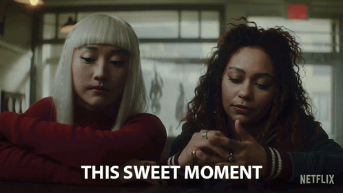 Two Women Sitting At A Table With The Words " This Sweet Moment " On The Bottom Right GIF