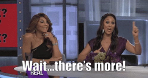 Two Women Sitting At A Table With The Words Wait There 'S More On The Screen GIF