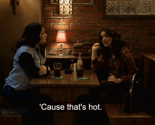 Two Women Sitting At Table With Hot Text GIF