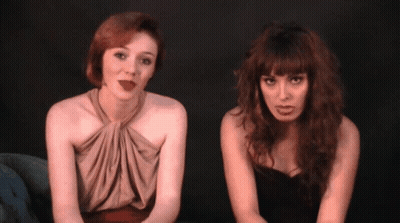 Two Women Sitting Next To Each Other One Wearing Lipstick GIF