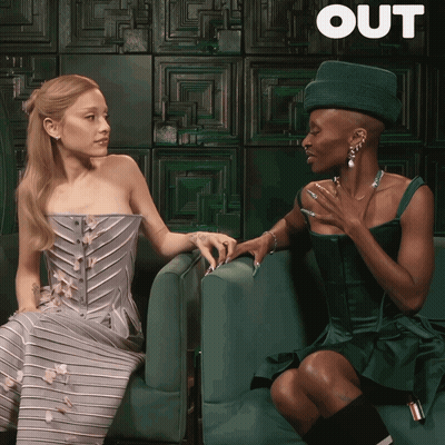 Two Women Sitting Next To Each Other Saying Out GIF