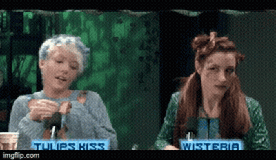 Two Women Sitting Next To Each Other With The Words Tulips Kiss On The Bottom GIF