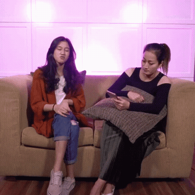 Two Women Sitting On Couch Looking At Cell Phones GIF
