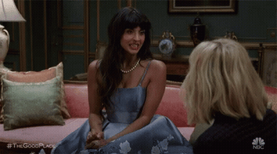 Two Women Sitting on Pink Couch Talking